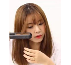 从刘海偏高一些的位置,直板夹从上向下拉一下,发尾注意向内卷.