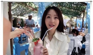 画面中的杨钰莹身着白色的风衣外套，左手上戴戒指的位置引人遐想